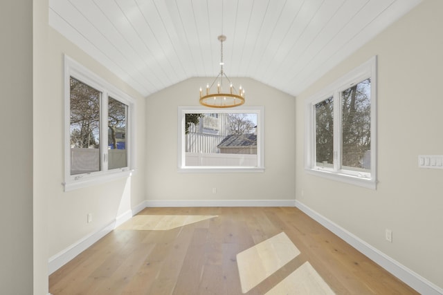 63 Ovington Dr, East Falmouth, MA 02536 - spare room with wood-type flooring, a notable chandelier, baseboards, and lofted ceiling