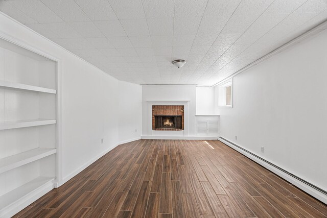 26 Hinckley Cir, Osterville, MA 02655 - unfurnished living room featuring a baseboard radiator, a brick fireplace, built in shelves, and dark wood-type flooring