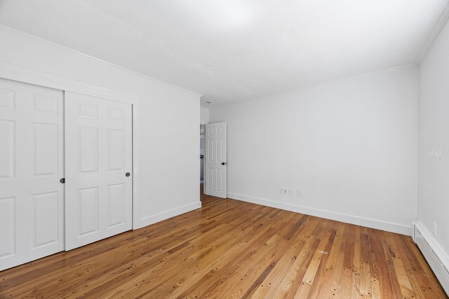 26 Hinckley Cir, Osterville, MA 02655 - unfurnished bedroom with baseboard heating, light wood-type flooring, ornamental molding, and a closet