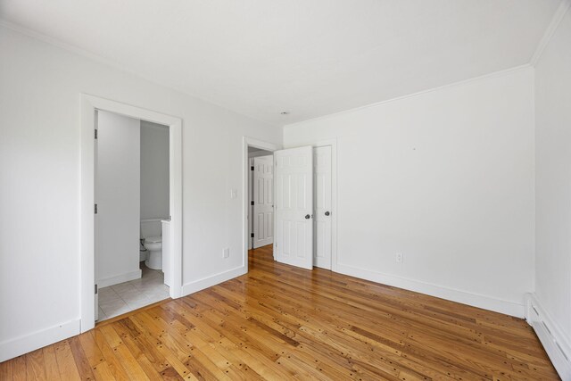 26 Hinckley Cir, Osterville, MA 02655 - unfurnished bedroom with a baseboard heating unit, light wood finished floors, and connected bathroom