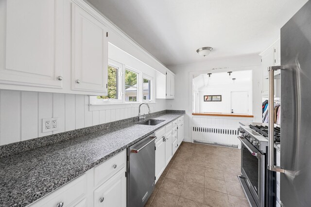 26 Hinckley Cir, Osterville, MA 02655 - kitchen with radiator heating unit, appliances with stainless steel finishes, white cabinets, tile patterned floors, and dark stone counters