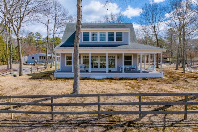 view of front facade featuring a shingled roof, a fenced front yard, and a porch
