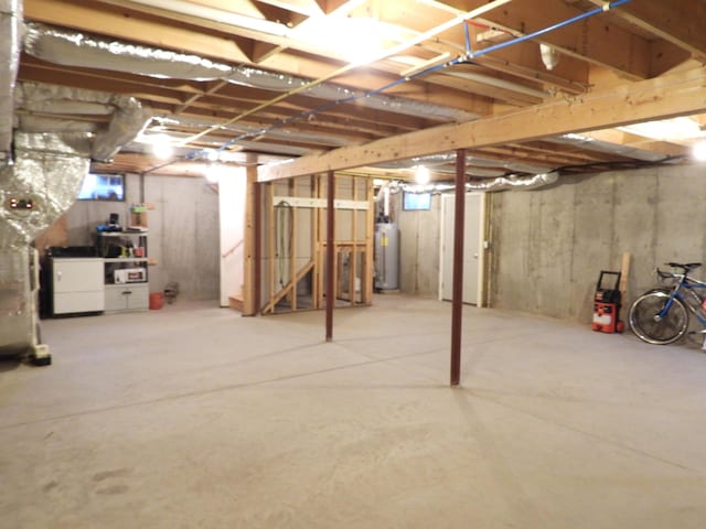 unfinished below grade area featuring washing machine and clothes dryer and water heater