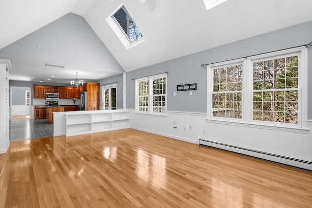 unfurnished living room with high vaulted ceiling, a skylight, baseboard heating, light wood finished floors, and an inviting chandelier