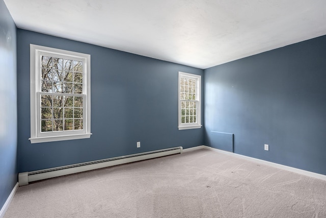 spare room with carpet, a baseboard heating unit, and baseboards