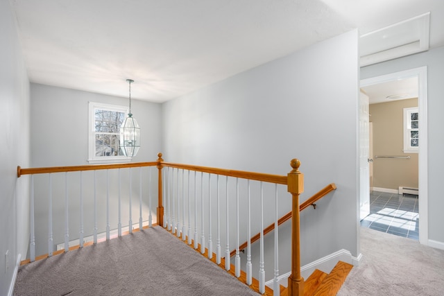 staircase featuring a baseboard heating unit, carpet, baseboards, and an inviting chandelier