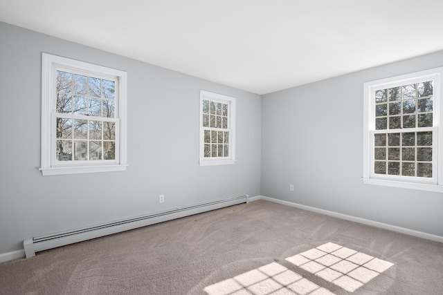 empty room featuring carpet, a baseboard heating unit, and baseboards