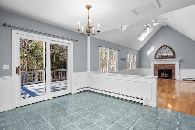 unfurnished dining area featuring a baseboard radiator, a brick fireplace, and a wainscoted wall