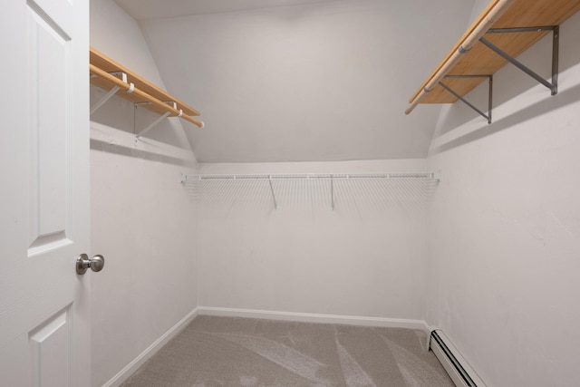 walk in closet featuring a baseboard heating unit, carpet, and lofted ceiling