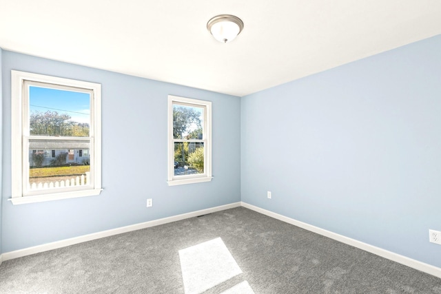 carpeted spare room featuring baseboards