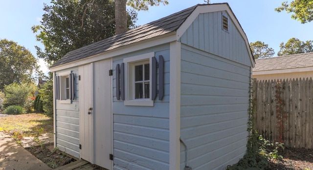 view of shed featuring fence