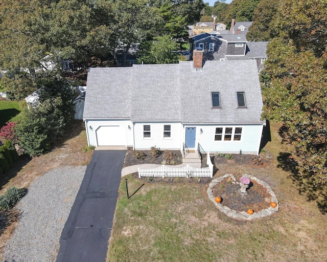 view of front facade featuring aphalt driveway, a chimney, an attached garage, a front yard, and fence