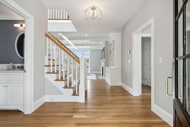 44 Tonset Rd, Orleans, MA 02653 - entrance foyer with light wood-style flooring, an inviting chandelier, baseboards, and stairs