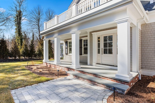 doorway to property with a balcony and a porch