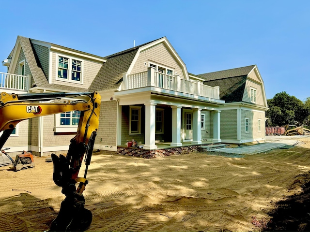 back of property featuring a balcony and a porch