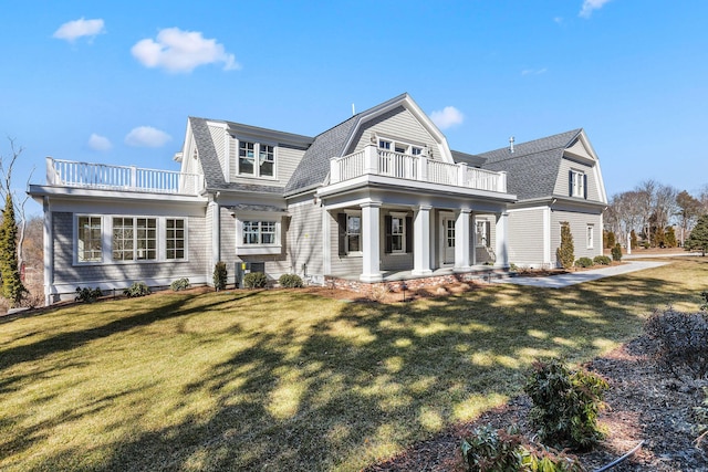 shingle-style home with roof with shingles, a front yard, a balcony, and a gambrel roof