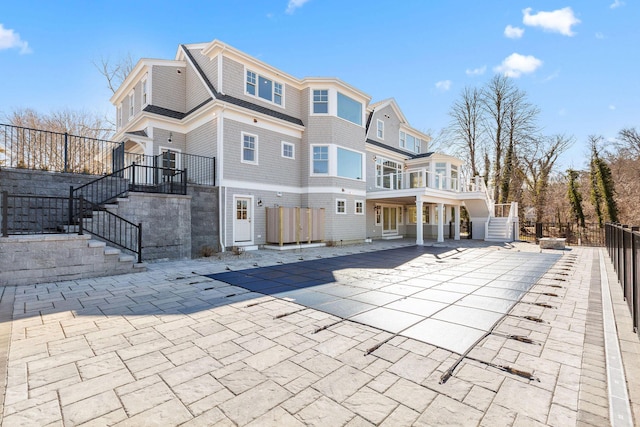 back of property featuring stairs and fence