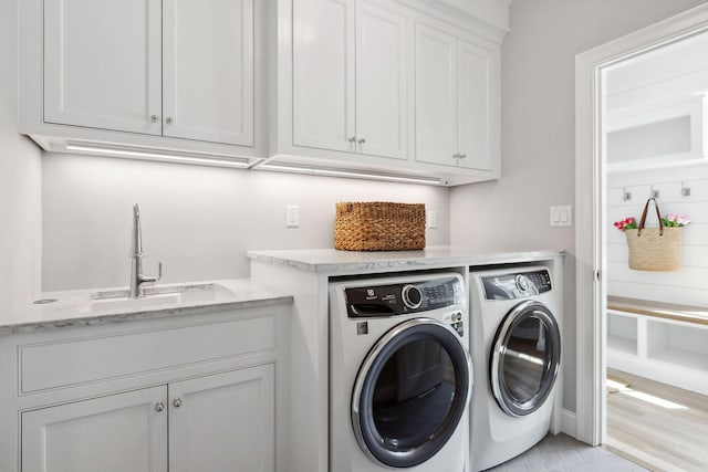 44 Tonset Rd, Orleans, MA 02653 - clothes washing area featuring a sink, washer and clothes dryer, cabinet space, and light wood-style floors