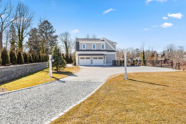 view of front of home featuring a front yard, decorative driveway, fence, and an attached garage