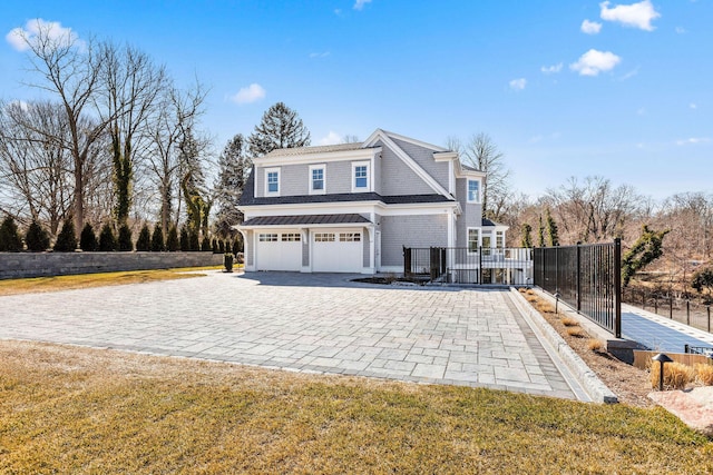 view of side of property featuring a garage, fence, and decorative driveway