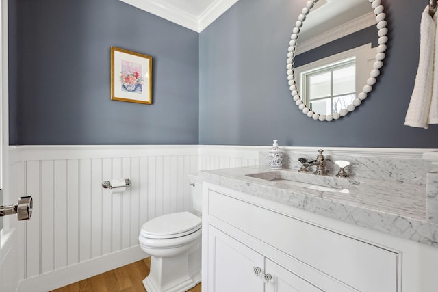 44 Tonset Rd, Orleans, MA 02653 - half bath featuring crown molding, vanity, toilet, wood finished floors, and wainscoting