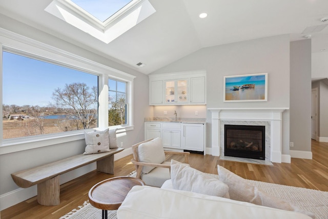 44 Tonset Rd, Orleans, MA 02653 - living room with baseboards, vaulted ceiling, wet bar, light wood-style flooring, and visible vents