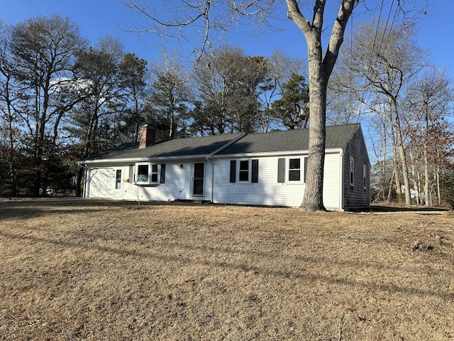 ranch-style house with a front lawn and a chimney