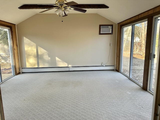 unfurnished room with a wall unit AC, a baseboard radiator, vaulted ceiling, and carpet flooring