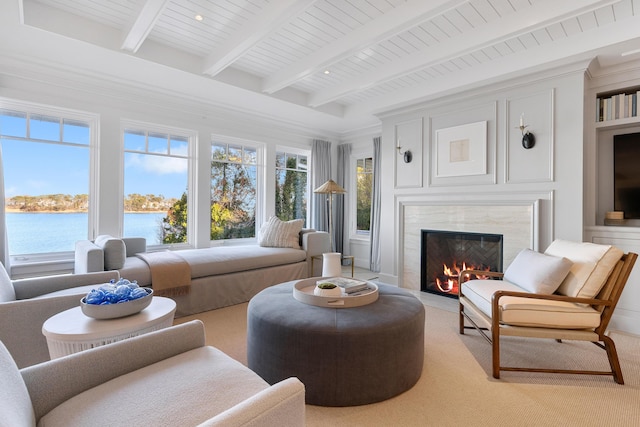 sunroom featuring wooden ceiling, beam ceiling, a water view, and a high end fireplace