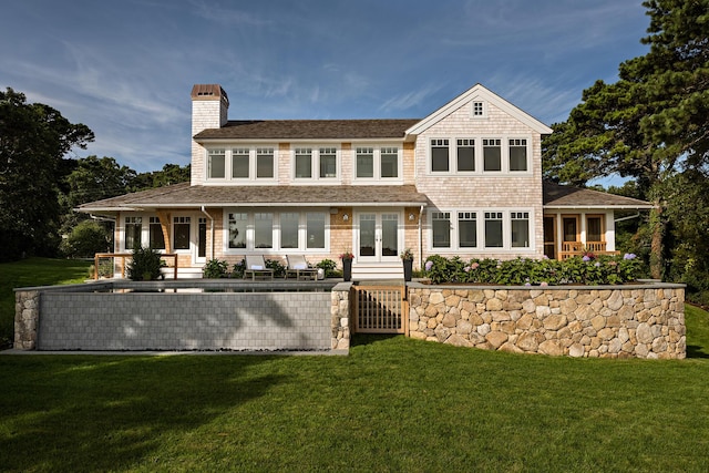 rear view of house with french doors, a lawn, and a chimney