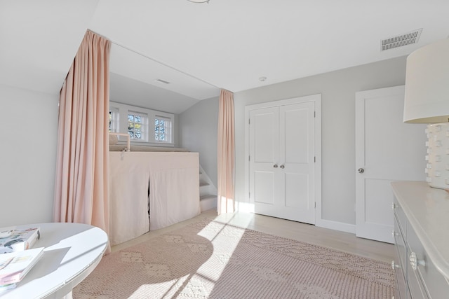 bathroom featuring vaulted ceiling, wood finished floors, visible vents, and baseboards