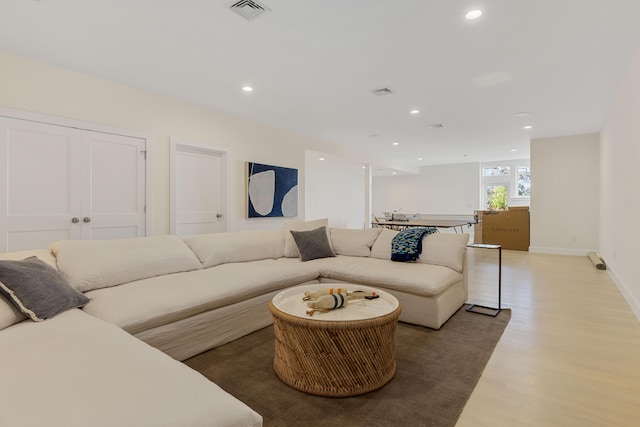 living area featuring baseboards, light wood-style flooring, visible vents, and recessed lighting