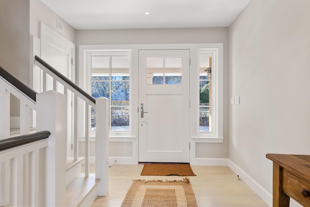 entrance foyer with light wood-style floors, visible vents, and baseboards