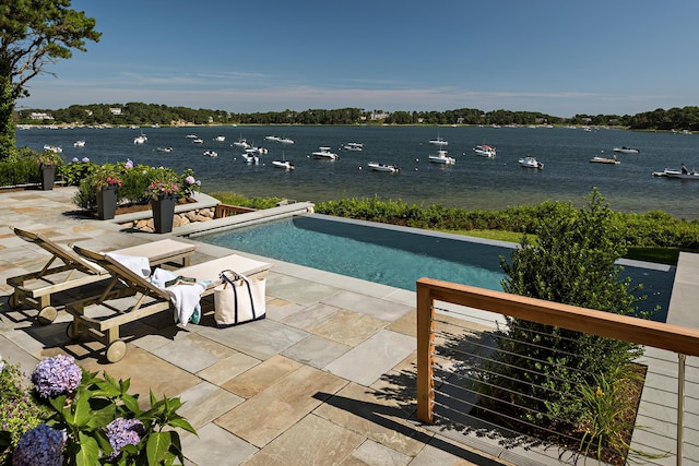 view of pool with a patio area and a water view