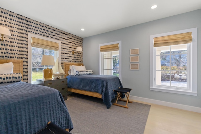 bedroom with multiple windows, baseboards, wood finished floors, and recessed lighting