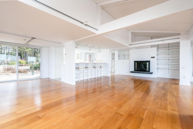 unfurnished living room featuring a brick fireplace, hardwood / wood-style floors, and built in features