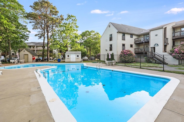 view of swimming pool with a storage shed