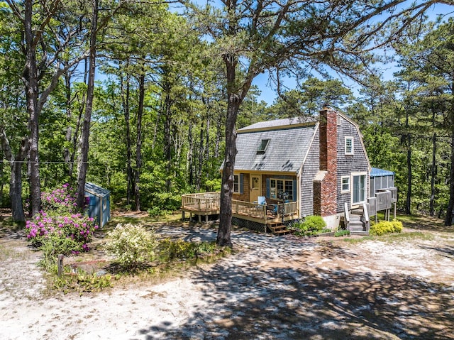 40 Georges Way, Wellfleet, MA 02667 - view of front of house with a gambrel roof, a wooden deck, a chimney, and roof with shingles