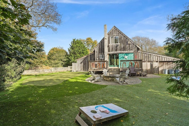 rear view of house with a deck and a lawn