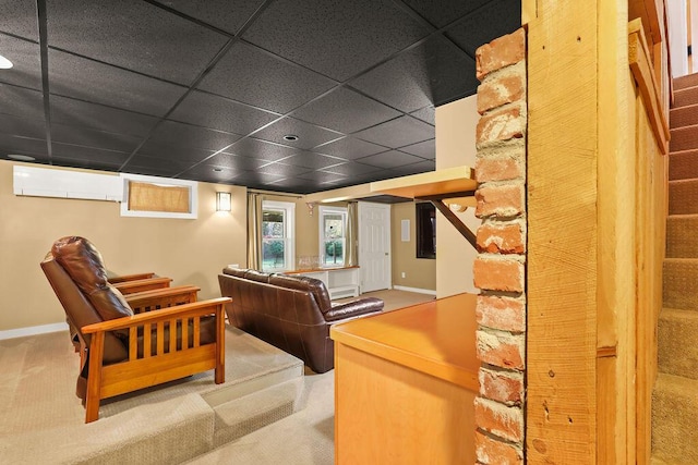 carpeted home theater featuring a baseboard radiator, a paneled ceiling, and a wall mounted air conditioner