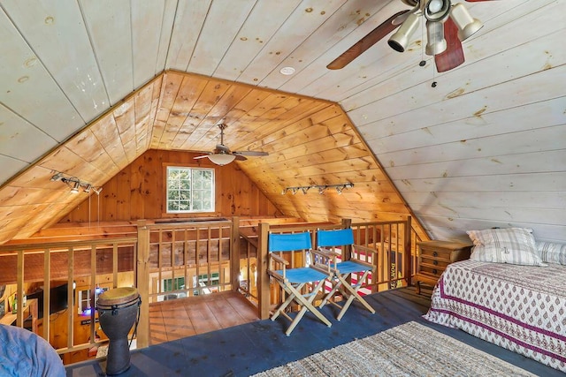 bedroom featuring vaulted ceiling, wooden ceiling, ceiling fan, and wood walls