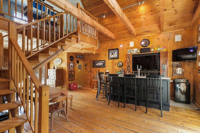 interior space featuring beamed ceiling, light hardwood / wood-style flooring, wood ceiling, and wood walls