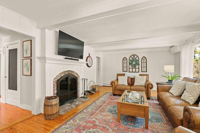 living room featuring hardwood / wood-style flooring, a brick fireplace, a wall mounted air conditioner, and beam ceiling