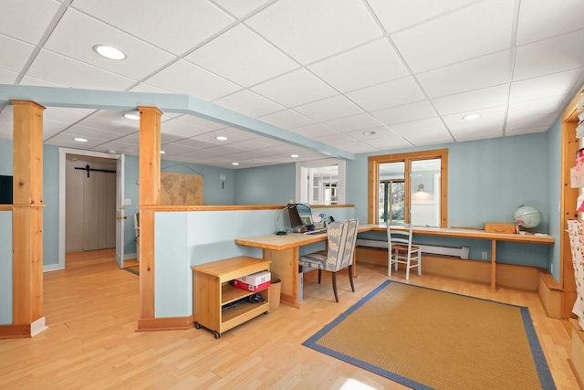 playroom featuring hardwood / wood-style flooring, a baseboard heating unit, and decorative columns