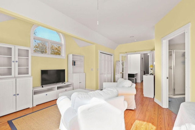 living room featuring vaulted ceiling and light wood-type flooring