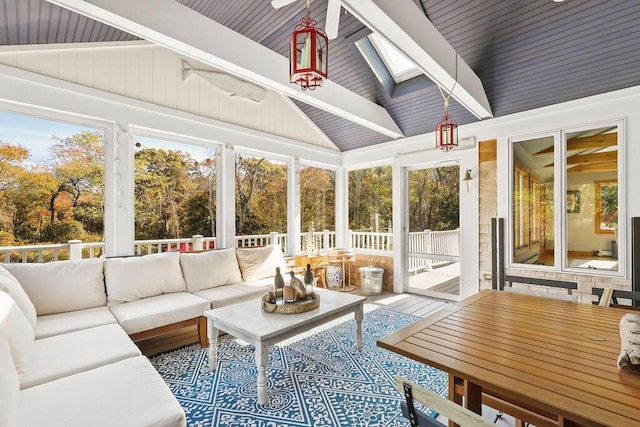 sunroom / solarium featuring lofted ceiling with skylight