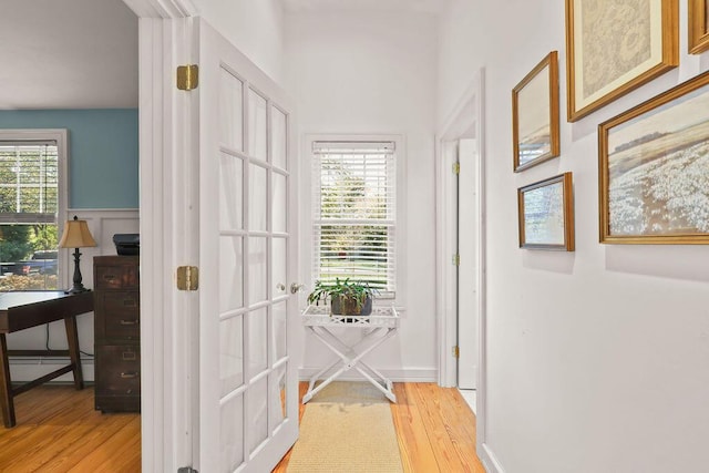 doorway to outside featuring a baseboard heating unit and light hardwood / wood-style floors