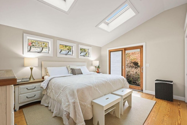 bedroom with access to exterior, light hardwood / wood-style flooring, and lofted ceiling with skylight