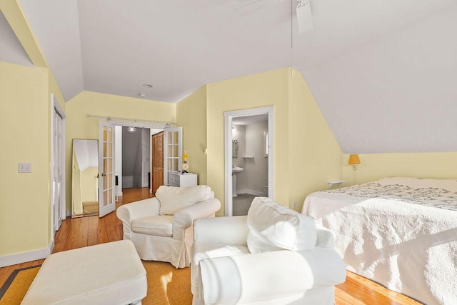 bedroom with connected bathroom, vaulted ceiling, french doors, and ceiling fan