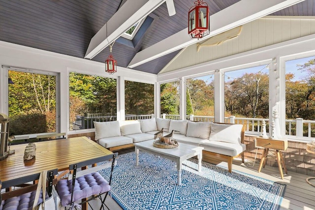 sunroom featuring lofted ceiling with skylight and plenty of natural light